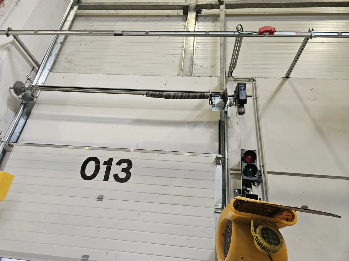 Molle a torsione e binari di una porta sezionale a Bologna