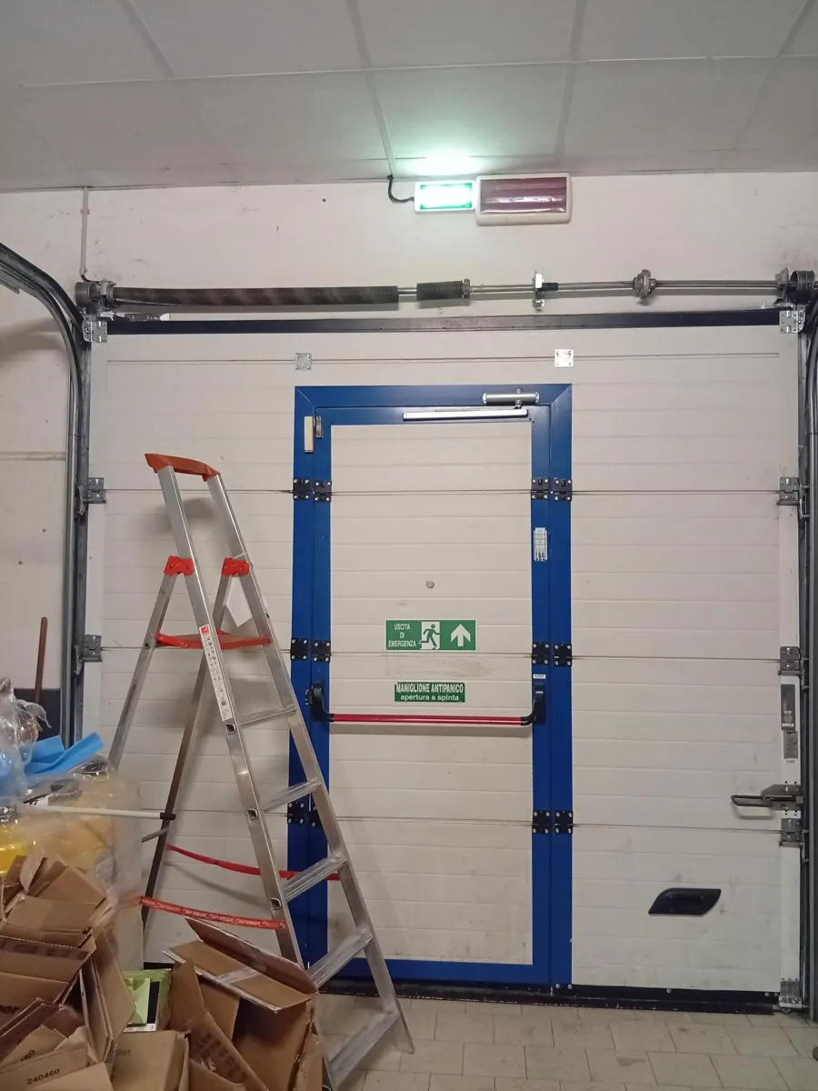 Porta sezionale industriale con porta pedonale a Bologna